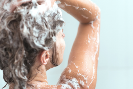 Shampoo hair in the shower.